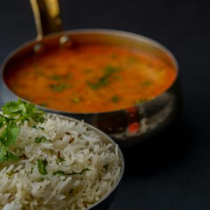 Tasty Indian dal with basmati rice garnished with fresh herbs, perfect for a flavorful meal.